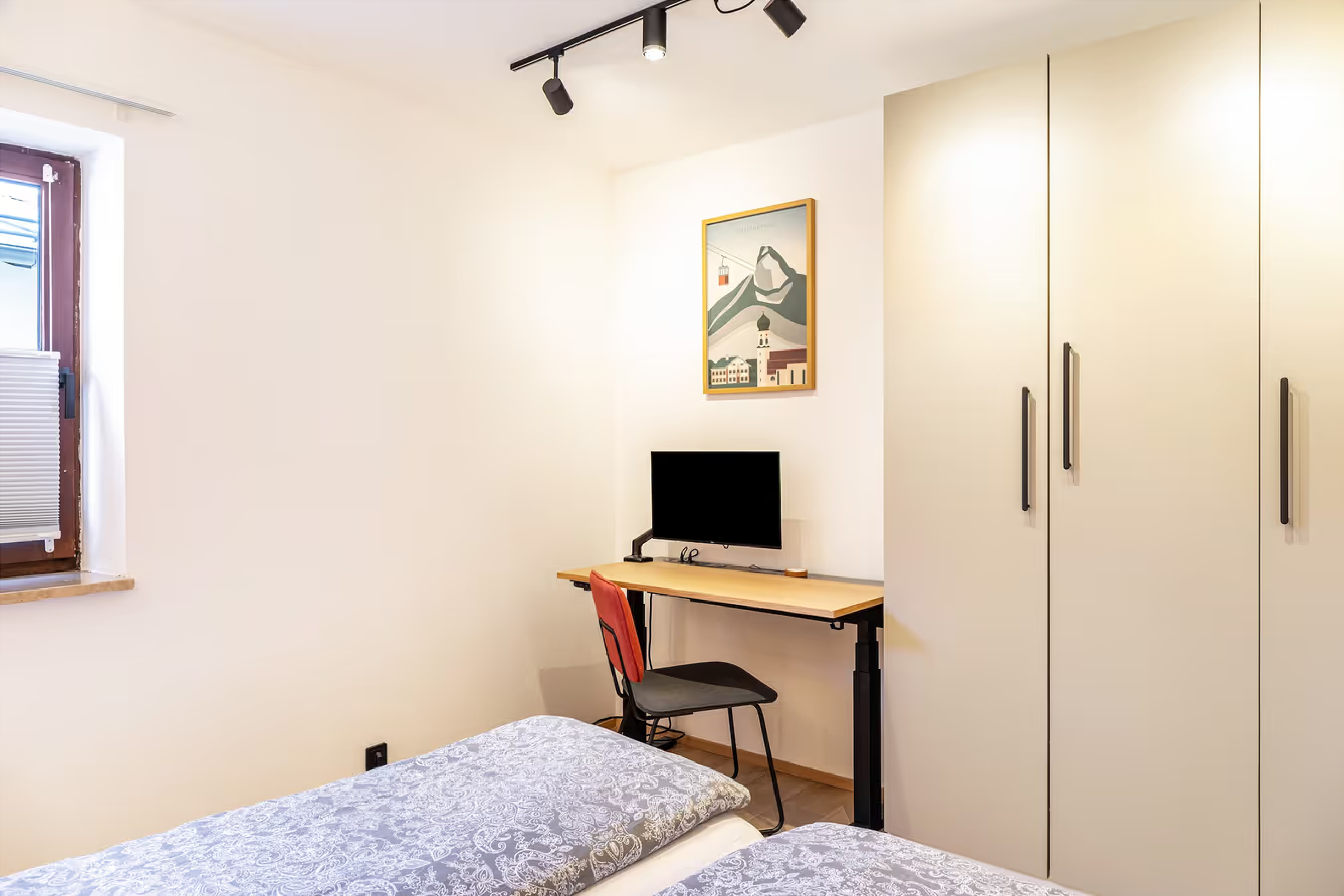 Workation-Arbeitsplatz mit Schreibtisch und Monitor im Schlafzimmer der Ammerstube